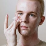 Man-in-Beige-Crew-Neck-Shirt-Covering-His-Face