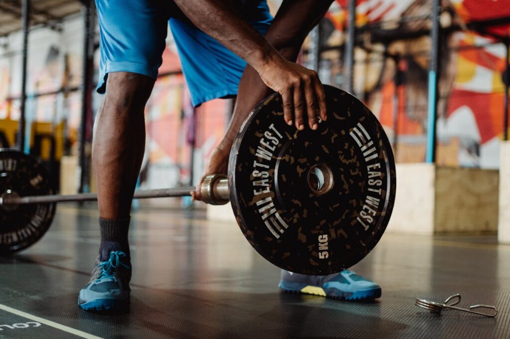 Man-in-Blue-Shorts-Putting-in-Weights-on-Barbell