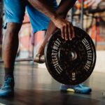 Man-in-Blue-Shorts-Putting-in-Weights-on-Barbell