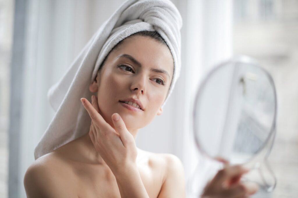 Selective-Focus-Portrait-Photo-of-Woman-With-a-Towel-on-Head-Looking-in-the-Mirror
