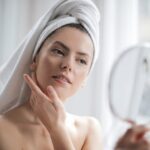 Selective-Focus-Portrait-Photo-of-Woman-With-a-Towel-on-Head-Looking-in-the-Mirror
