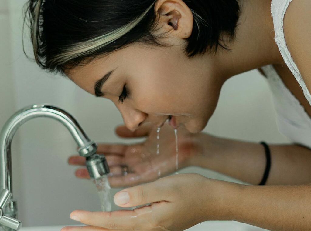 Woman-Washing-Her-Face-With-Water
