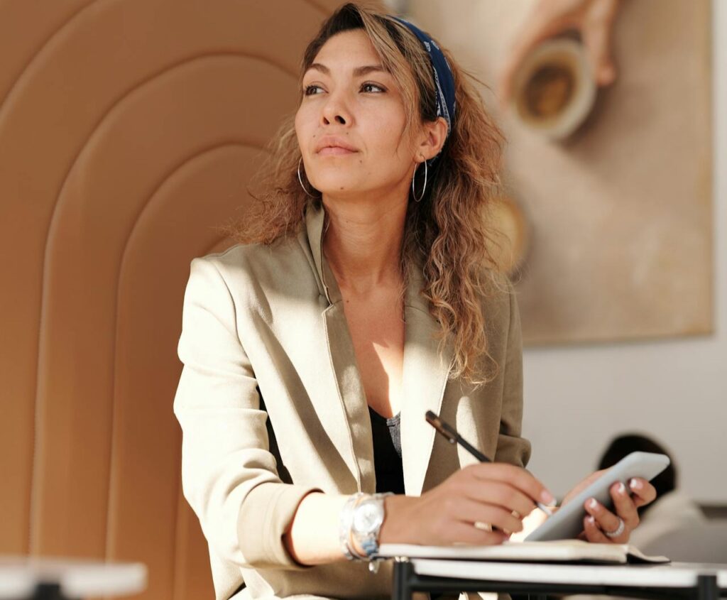 Woman-Wearing-Blazer-and-Blue-Denim-Jeans-Sitting-on-Chair