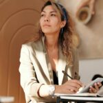 Woman-Wearing-Blazer-and-Blue-Denim-Jeans-Sitting-on-Chair