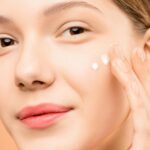 Woman-With-Pink-Lipstick-Applying-Facial-Cream