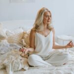 Woman-in-White-Tank-Top-Sitting-on-Bed