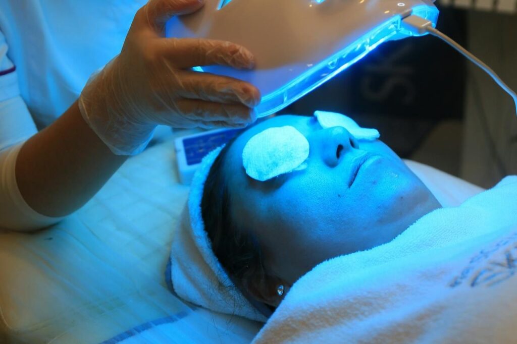 A-Beautician-Putting-an-LED-Face-Mask-on-a-Woman