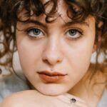 Close-Up-Shot-of-a-Curly-Haired-Woman-Looking-at-Camera