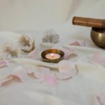 Lighted-Candle-Beside-a-Tibetan-Singing-Bowl-on-White-Linen