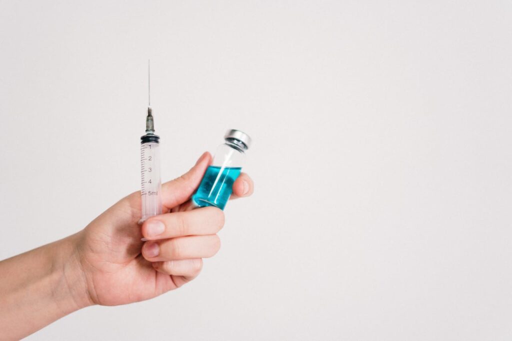Person-Holding-Syringe-and-Vaccine-Bottle