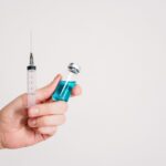 Person-Holding-Syringe-and-Vaccine-Bottle