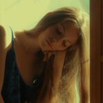 Woman-in-Blue-Sleeveless-Dress-Sitting-on-Window